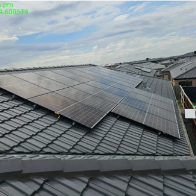 Solar panel array installed for 10.34kW solar system with 49.92 kWh Battery Storage on dark-tiled residential roof with cloudy sky in background