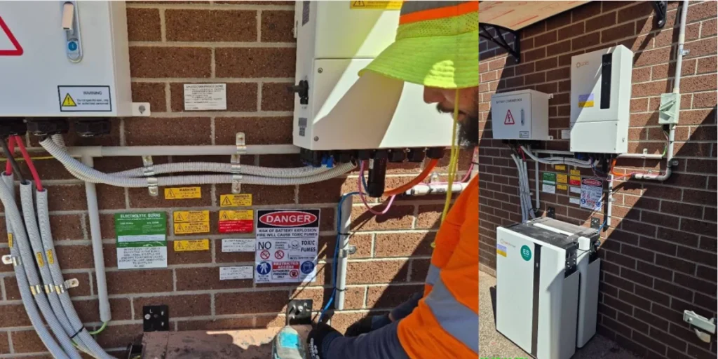 GES installer fitting safety signage and conduit beside the hybrid inverter and battery combiner box in Mickleham