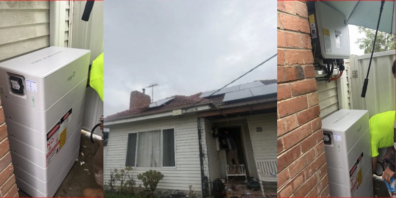 FoxESS battery stack and wall-mounted inverter being installed beside a weatherboard home in Sunshine North with rooftop solar panels in the background
